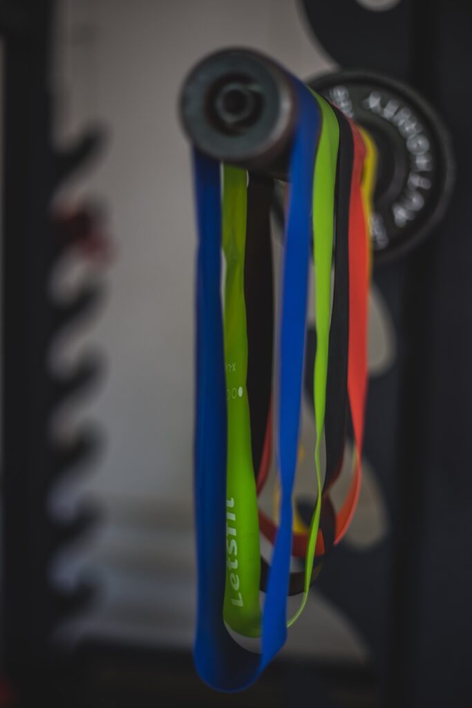 multiple resistance bands hanging from a barbell